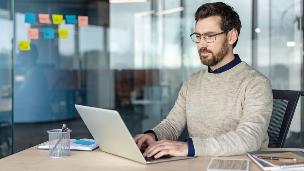 man typing on a computer at work