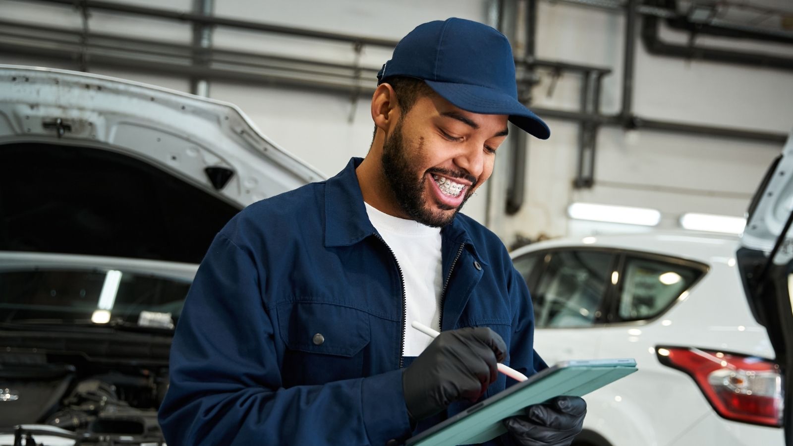 smiling mechanic writing something down