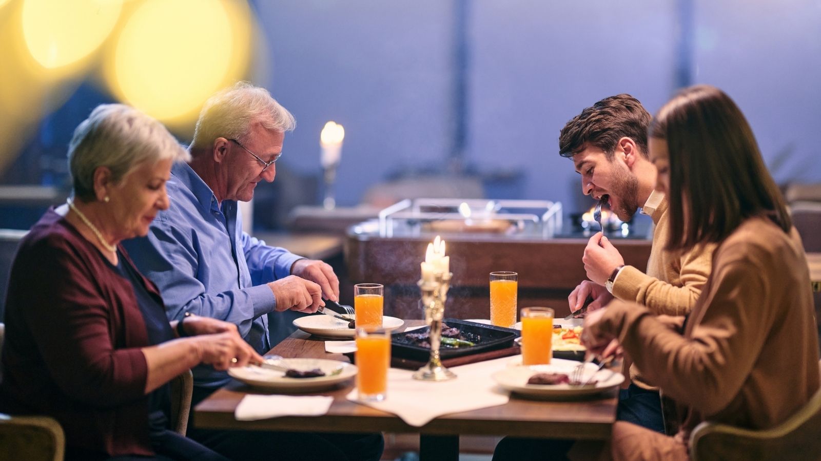 family of two older adults and two young adults at a restaurant