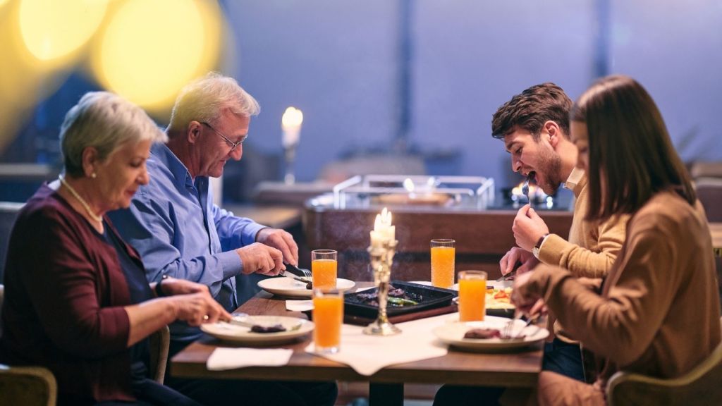 family of two older adults and two young adults at a restaurant