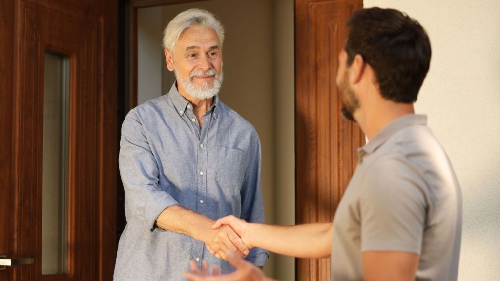 older man shaking hands with younger man