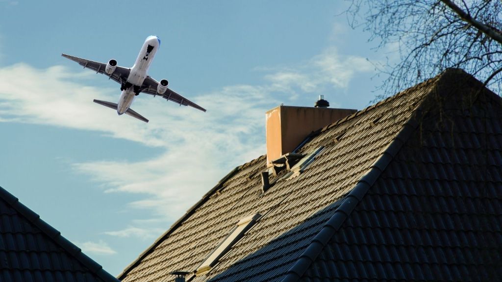 airplane flying over a house
