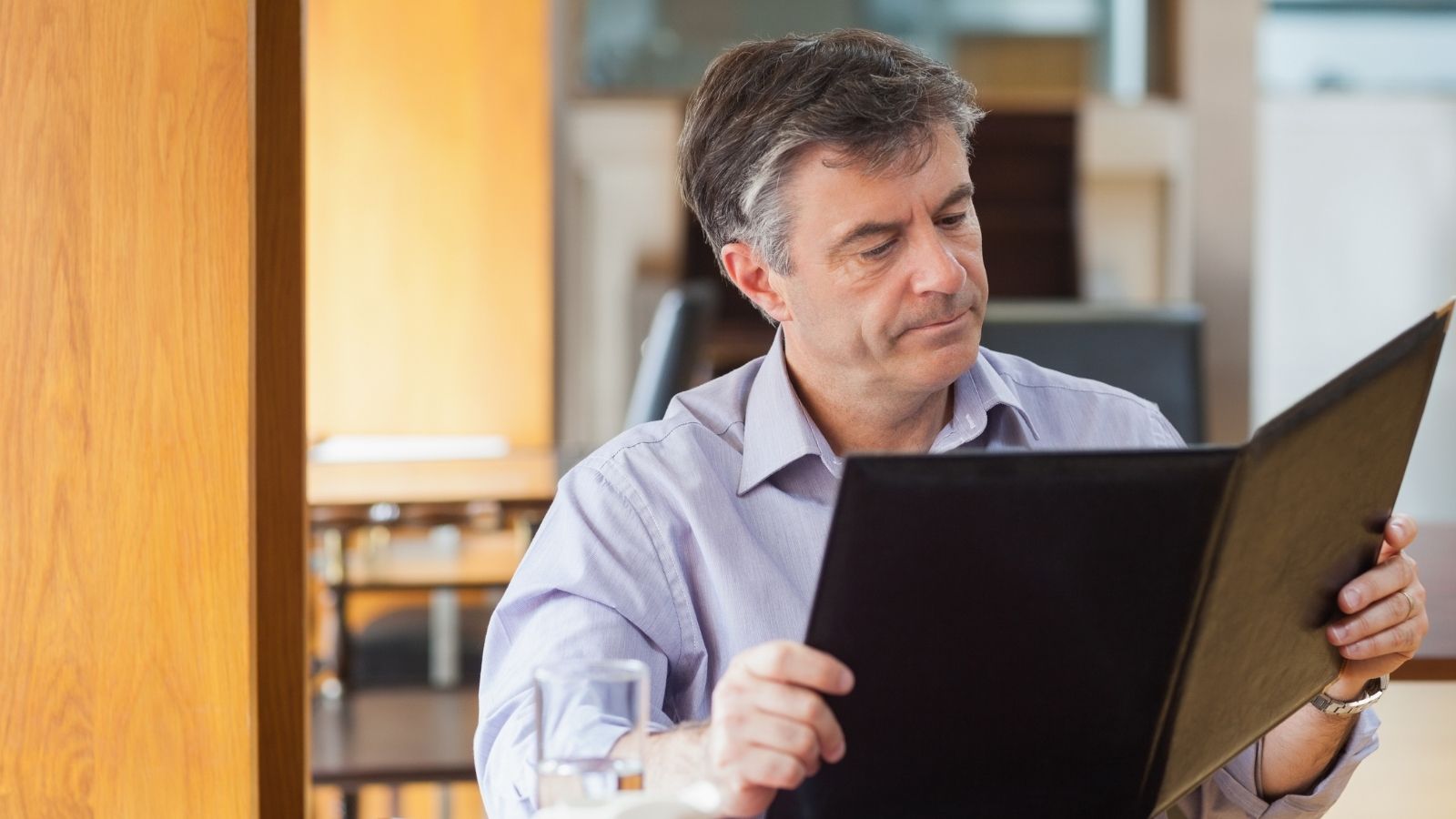 older man looking at menu