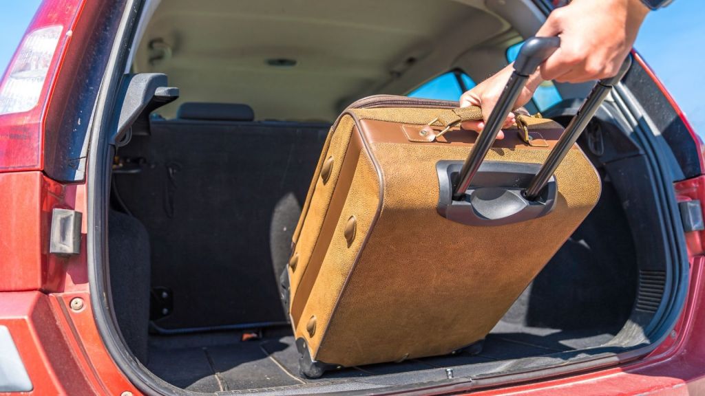 pulling suitcase out of the back of a car