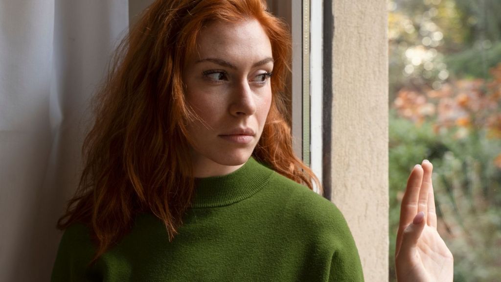 worried woman looking out the window