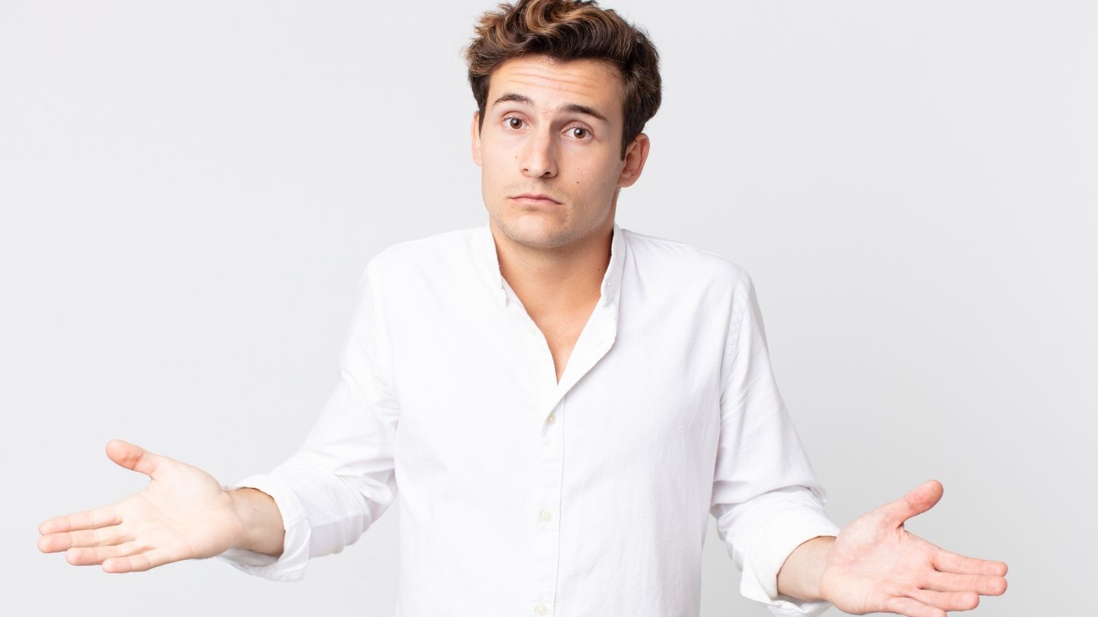man in a white shirt shrugging