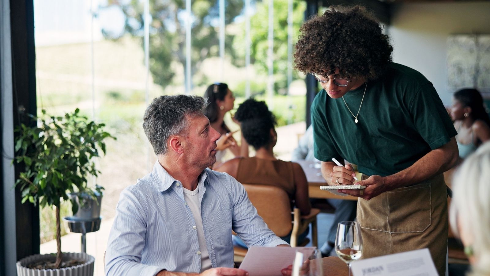waiter taking a man's order at a restaurant