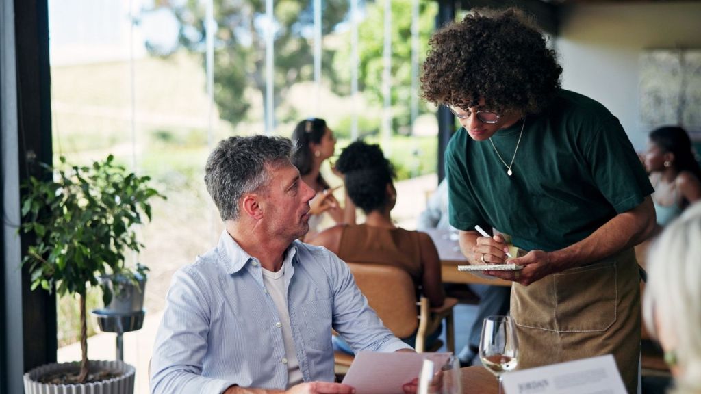 waiter taking a man's order at a restaurant