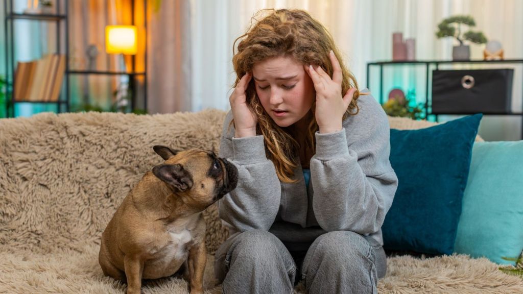 young stressed out woman sitting next to her dog