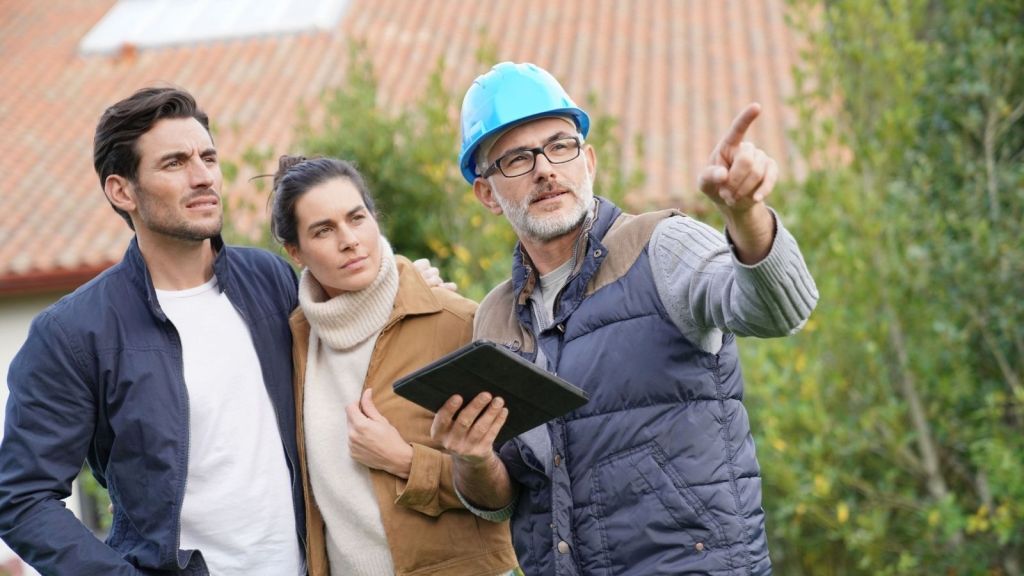 couple talking to contractor in backyard