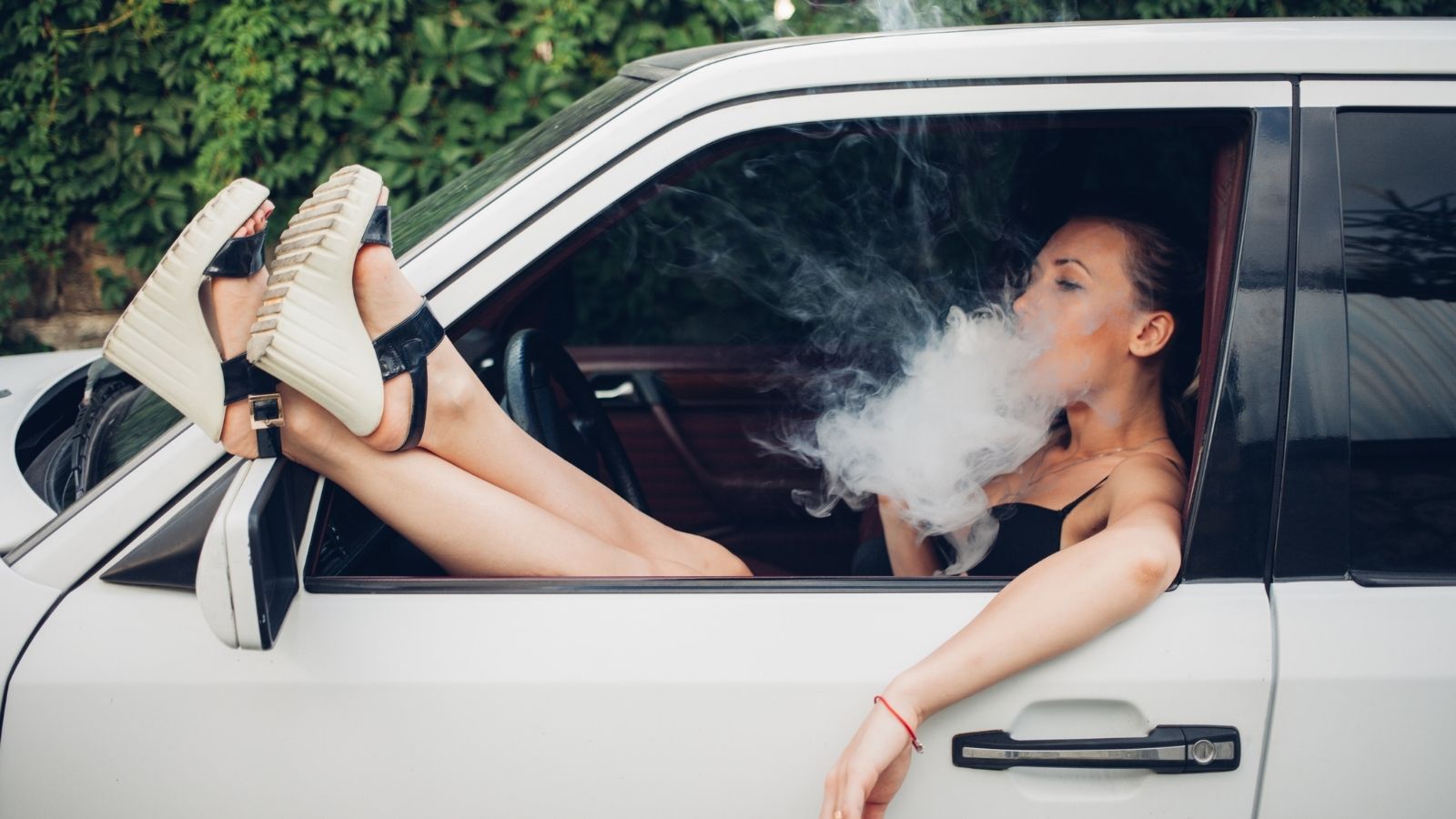Turn It Down: Neighborhood Reaches Boiling Point Over Woman’s Non Stop Car Concerts and Smoke woman sitting in car smoking