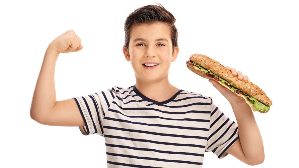 happy boy holding a big sub sandwich