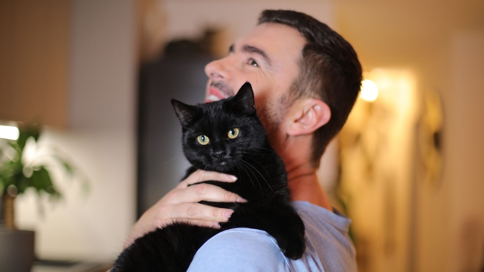 man holding a black cat