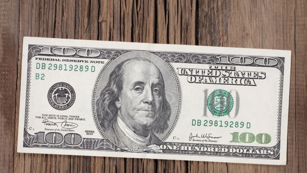 100 dollar bill on a wooden table