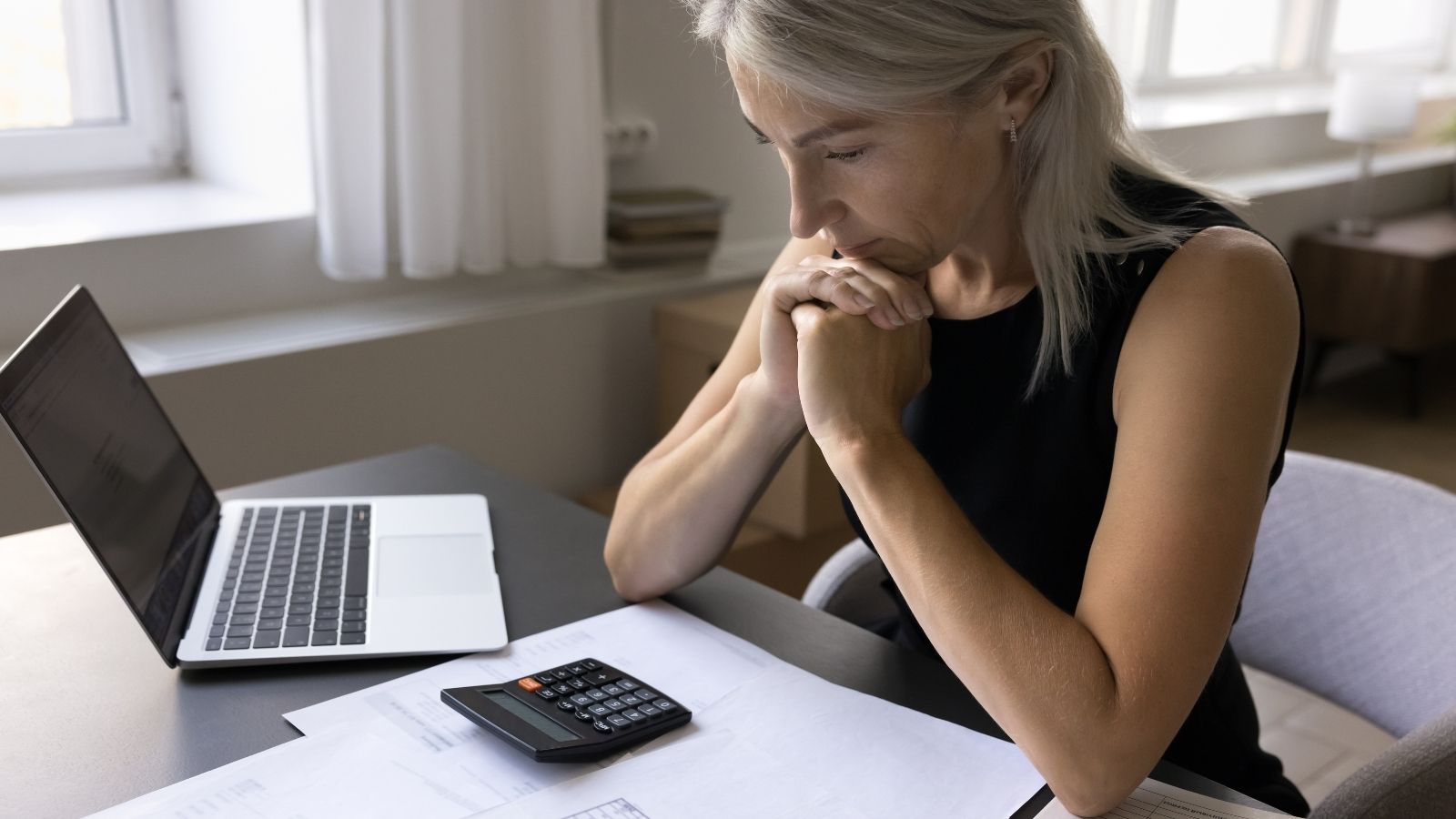 She Made a Firing Offense at Work. But Losing Her Job Means Losing the Insurance Keeping Her Alive. older businesswoman looking down thinking