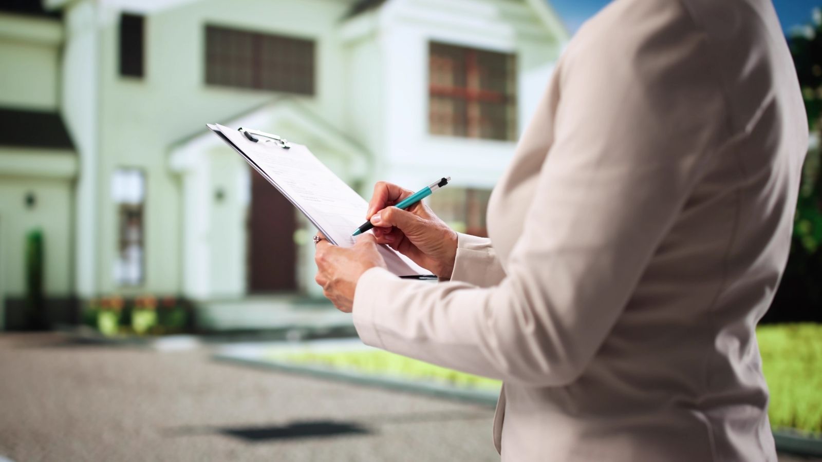 woman with a clipboard looking at a house