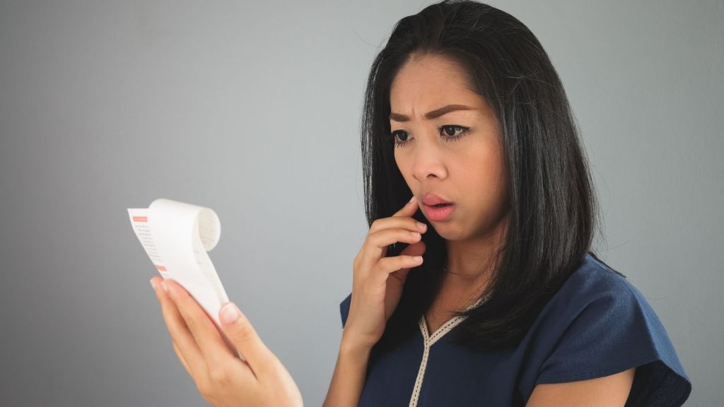 worried woman looking at her receipt