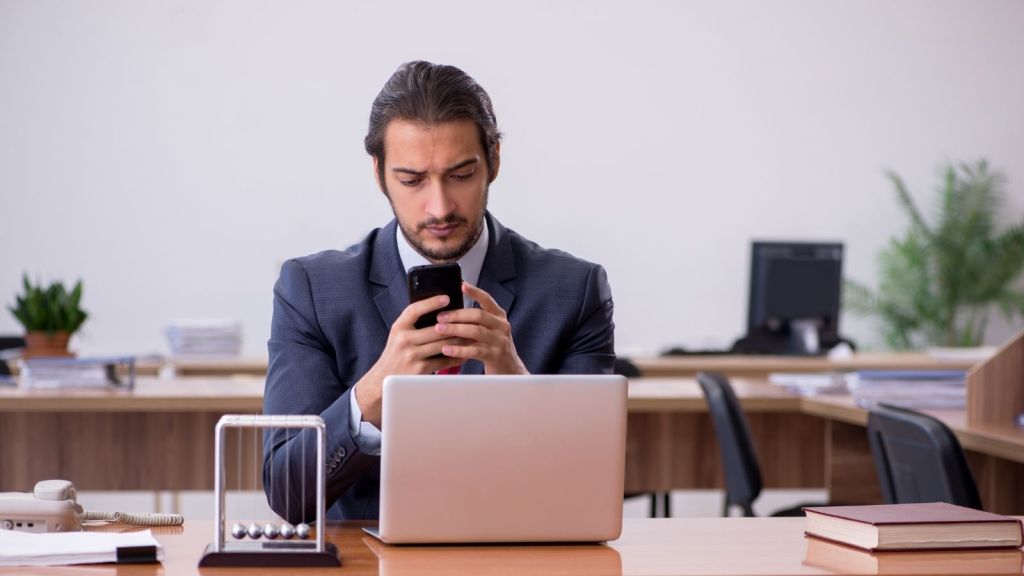 businessman looking at his phone at work