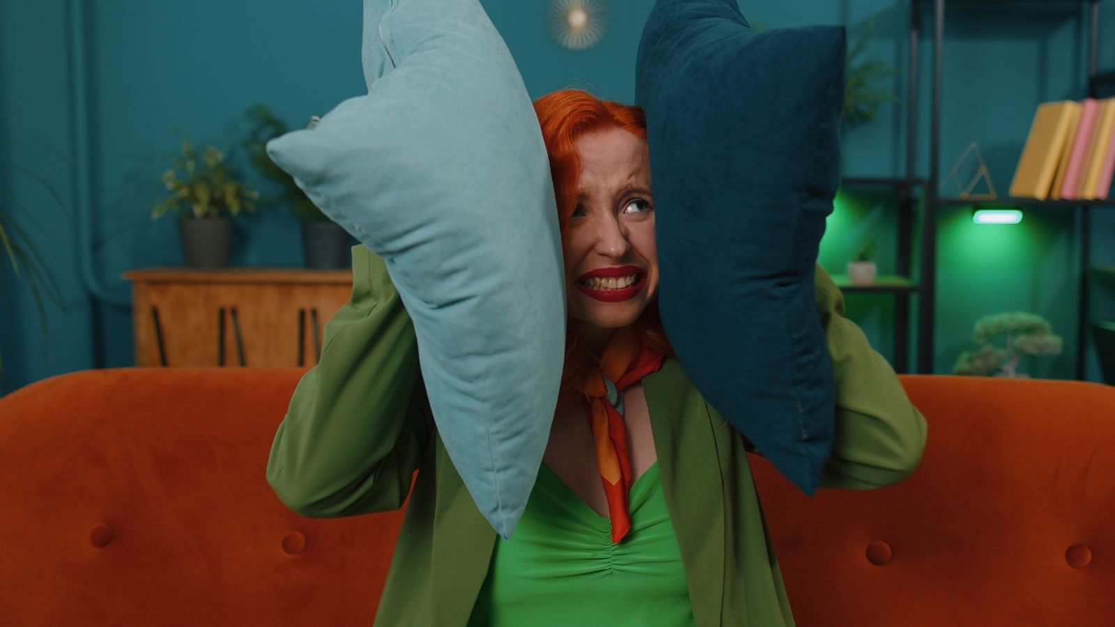 woman holding pillows to her ears to block out noise