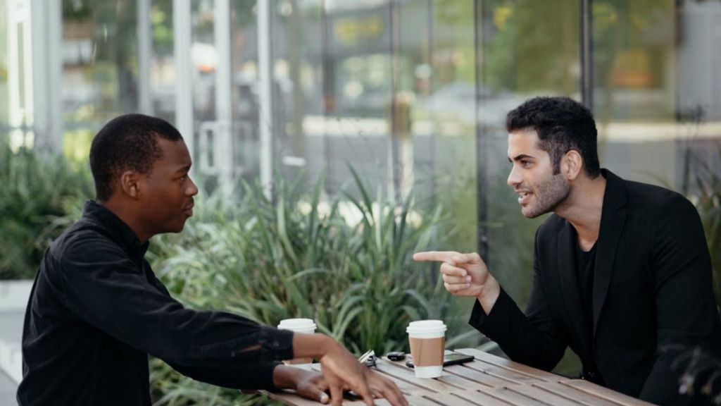 Two men having coffee and a conversation outdoors