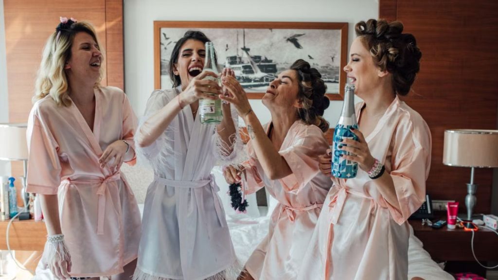 Bride and bridesmaids having fun during a bachelorette party in a hotel room