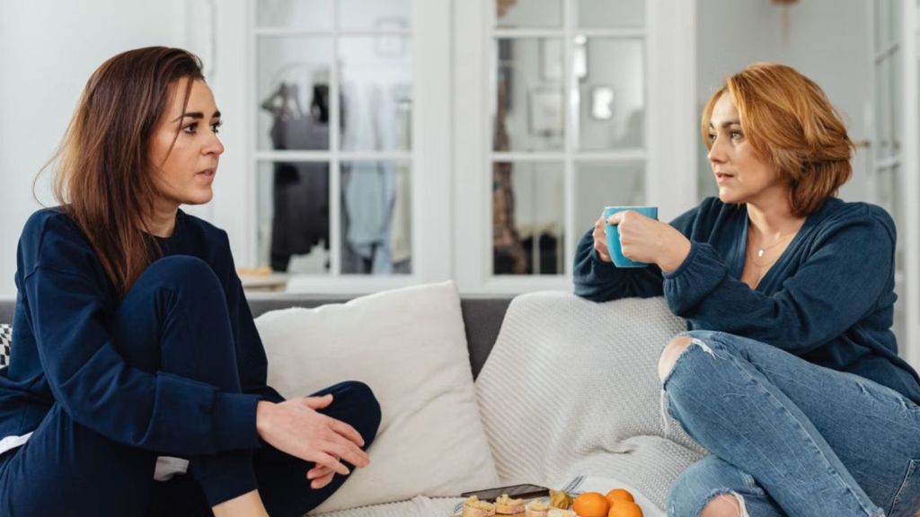 Two women sitting on the couch and talking