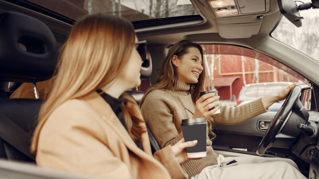 Two women riding in a car and having a fun conversation