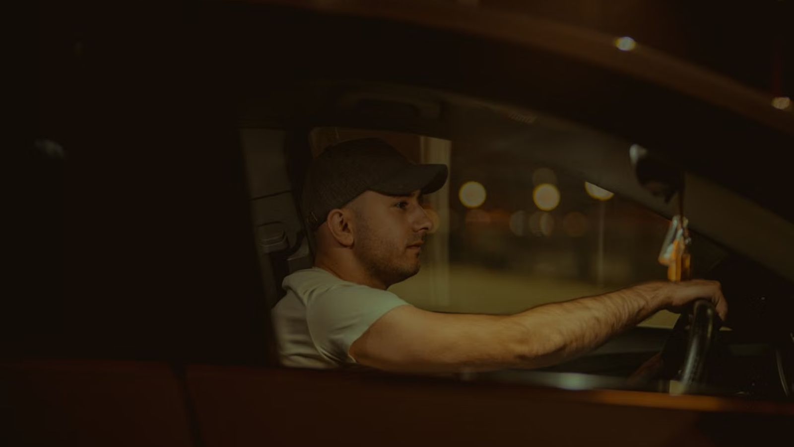 He Realized His Friend Was Crossing A Line With A Drunk Woman, So He Made A Drastic Decision Man wearing a cap driving a car at night