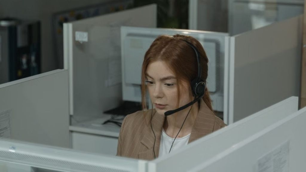 Woman with a serious face working as phone support in the office