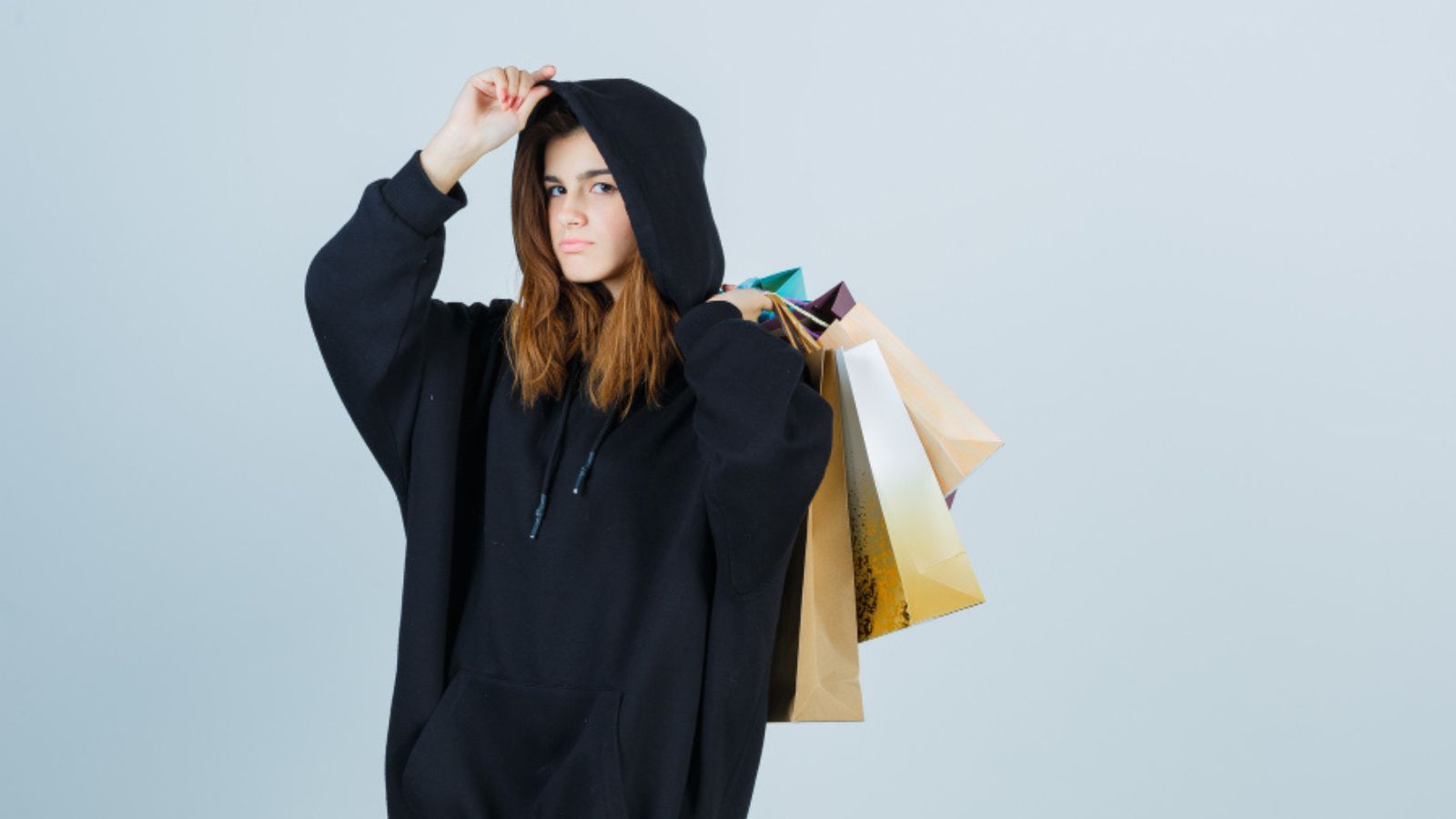 She Was Mistaken for a Tesco Worker as a Teenager — The Older Woman Who Asked Her for Help Was So Kind She Never Forgot Her Teenage girl wearing a black hoodie and carrying shopping bags