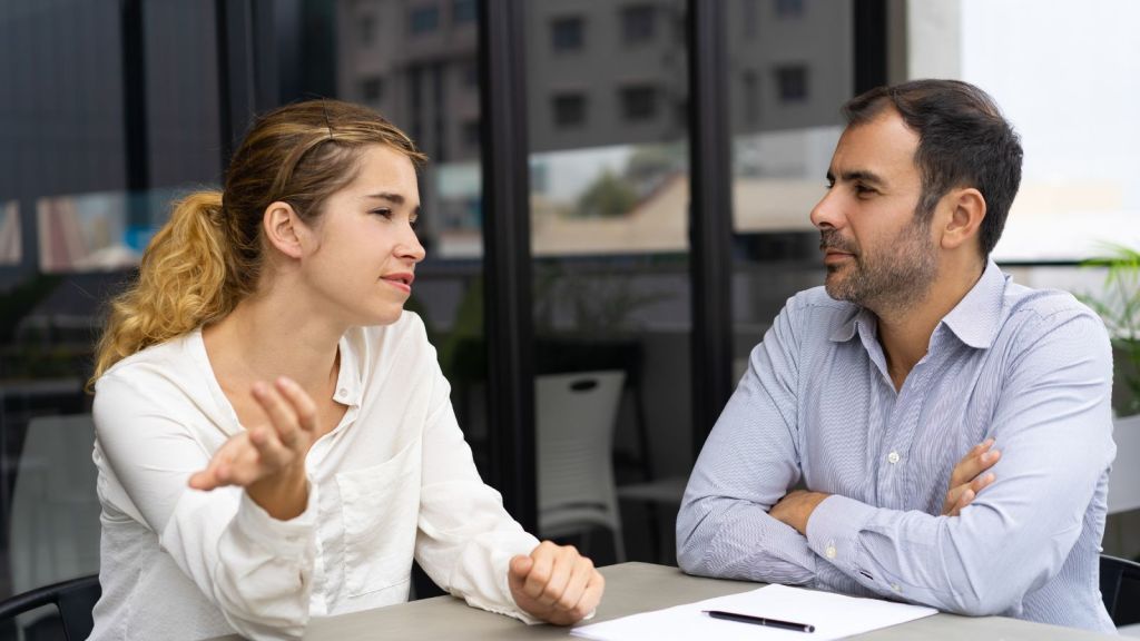 Man and woman in smart casual attire talking outdoors