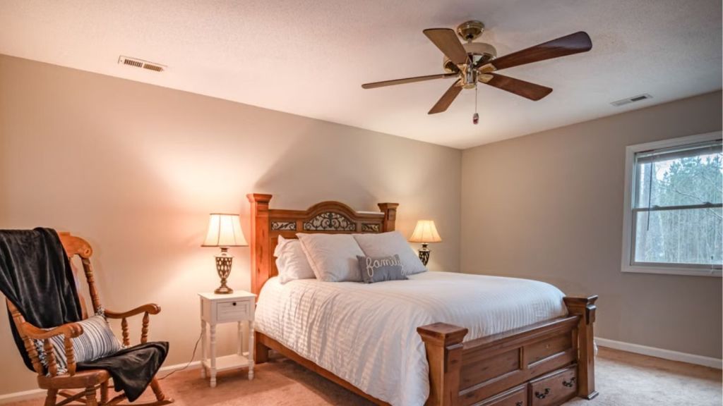 A clean and vibrant room with bed, lamps, and a ceiling fan