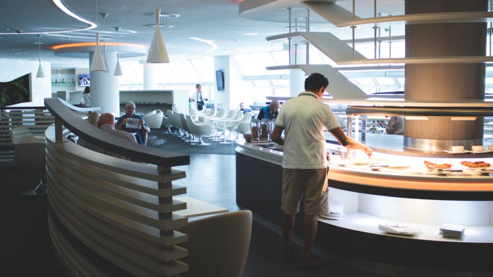 He Wanted to Use His Credit Card Perk for a Free Lounge Meal During Their Layover — His Wife Said He Was Abandoning Her Passengers hanging out at the airport lounge with buffet food