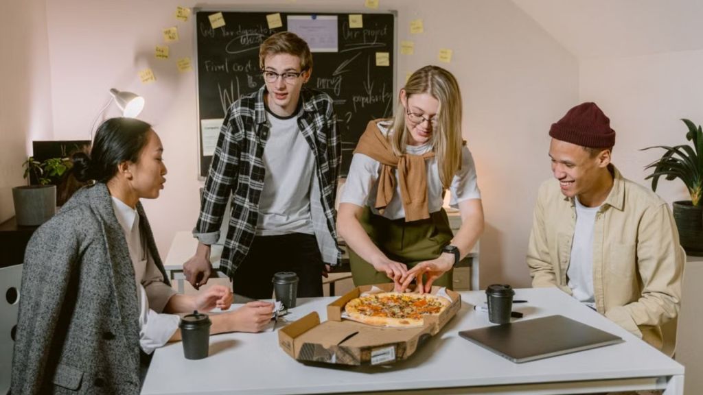 Employees enjoying some pizza in the office
