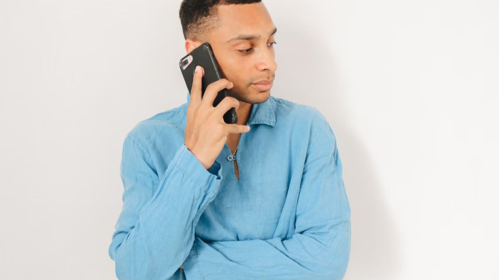 He Picked Up Her Ringing Phone, And Instantly Discovered His Sister Was Drowning in Secret Debt Man in blue long-sleeves shirt is talking on his phone