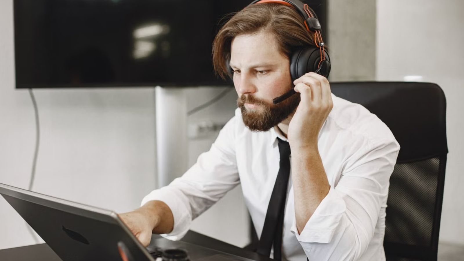 Tech Support Employee Helped His Company Through Bankruptcy, but Later Learned a Manager Tried to Keep Him From Leaving Tech support officer talking on his mic in front of his laptop