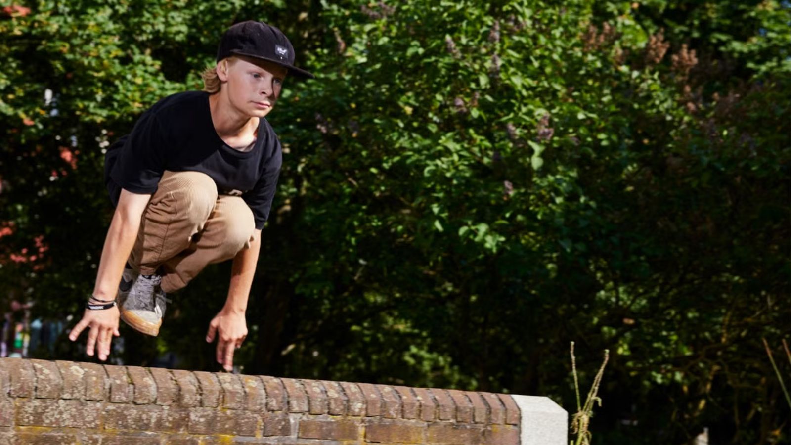 Teenage boy trying to jump over the fence