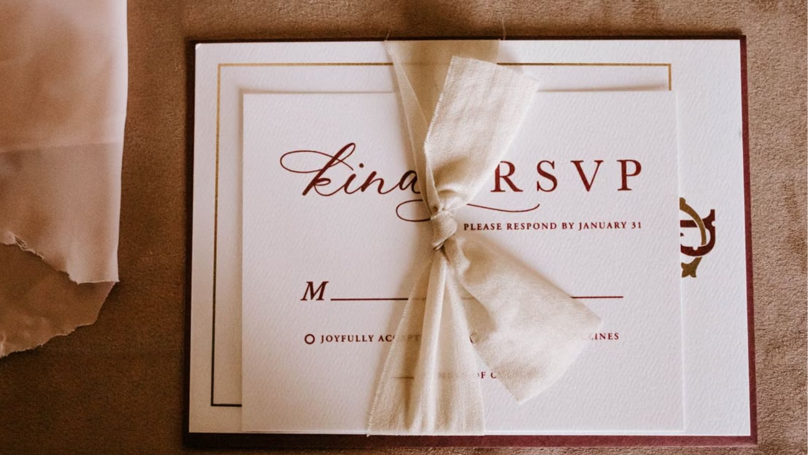 Cousin’s Wedding Brings Up Old Family Tensions, Leaving Guest Unsure Whether to Attend A wedding RSVP card tied with a white ribbon