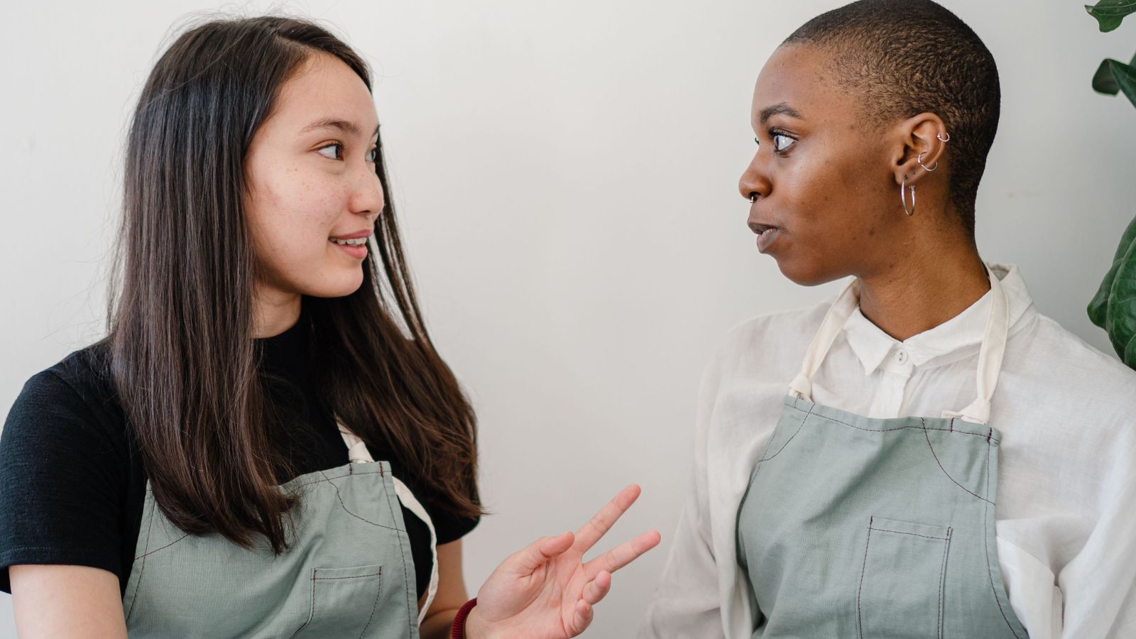 She Protected Her Time Off, but a Coworker’s Childcare Struggles Left Her Torn Between Boundaries and Empathy Two female workers wearing an apron talking to each other