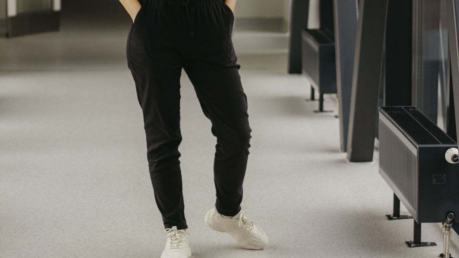 He Paid a Premium for Tough Work Pants. Instead, He Got Cheap Fabric That Ripped on the First Bend. Person wearing black pants on a hospital hallway
