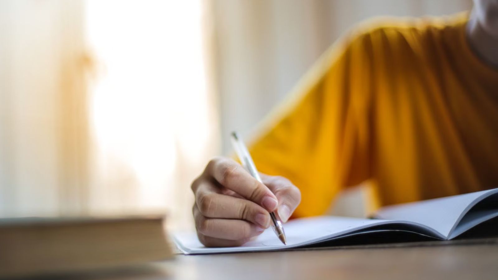 Teen Endures Painful Hand Cramps to Show His Grandmother Why He Couldn’t Keep Writing Teenager writing on a notebook using a pen