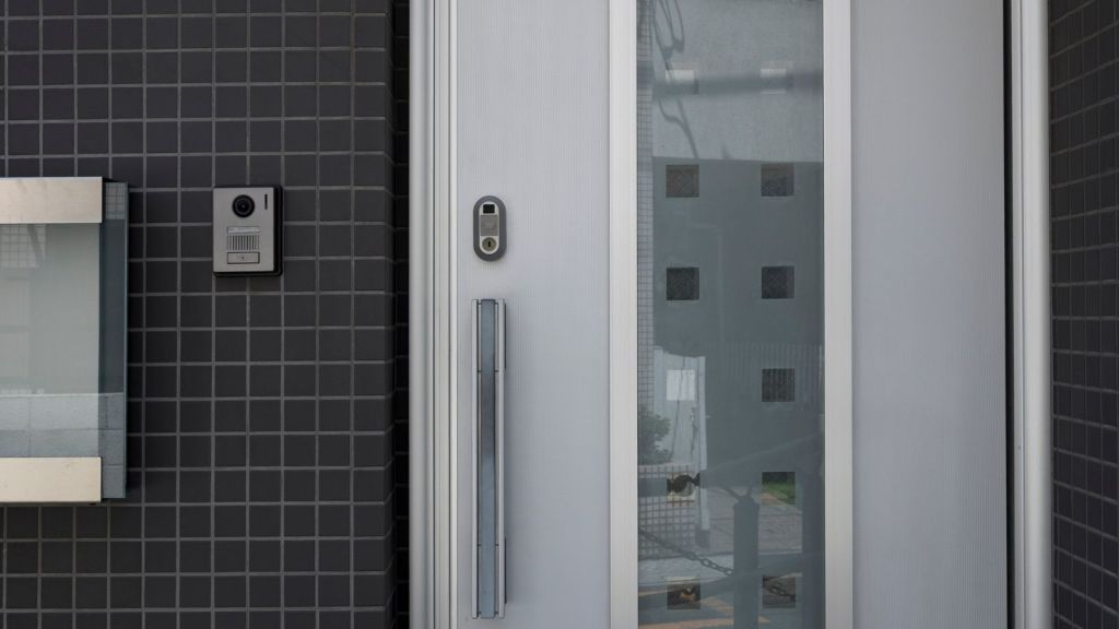 Front door of a house with a camera and speaker on the side