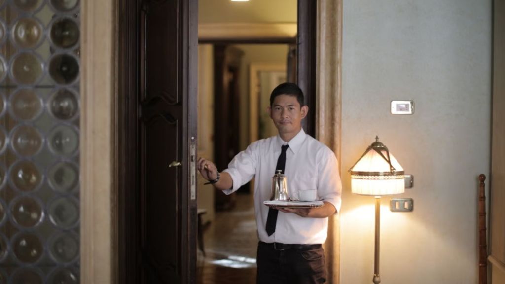 Hotel employee carrying a tray in an elegant hotel room