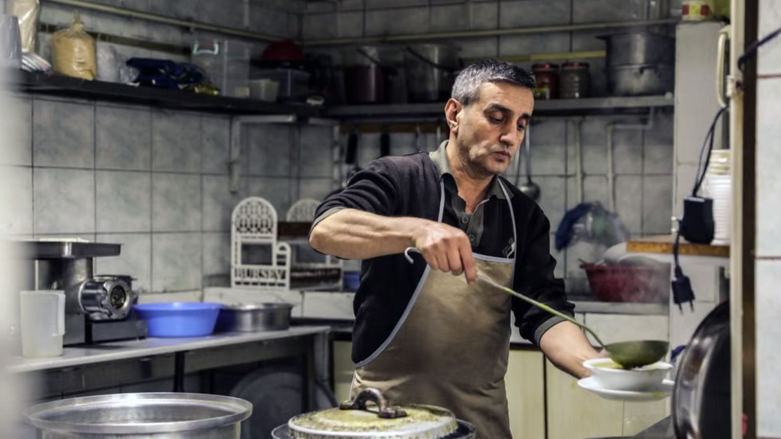 Man wearing an apron working in a kitchen