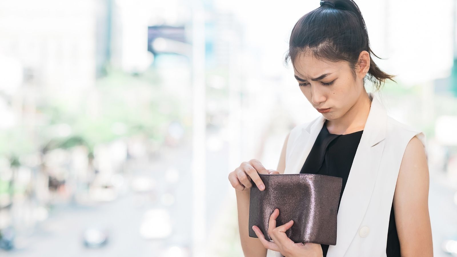 How a Boyfriend’s Shocking Logic for Emptying a Purse Backfired Into a Total Relationship Reckoning sad woman looking in her wallet