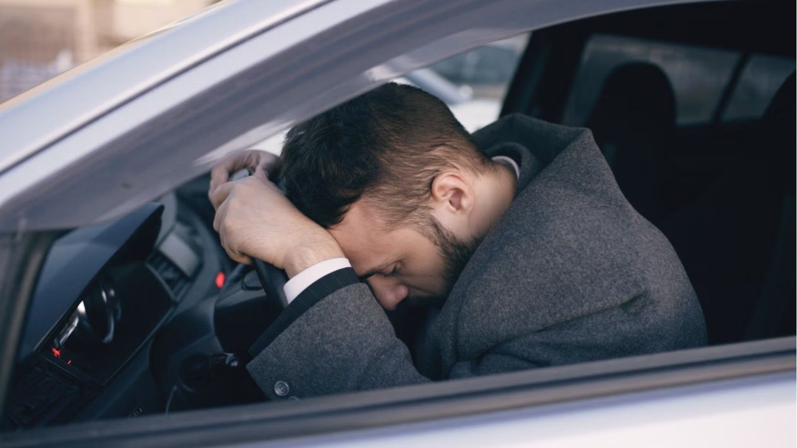 Man Didn’t Want To Drive After A Long Workday—But His Girlfriend Was Upset About The Change Of Plans Man feeling tired wiht his head on the car's steering wheel