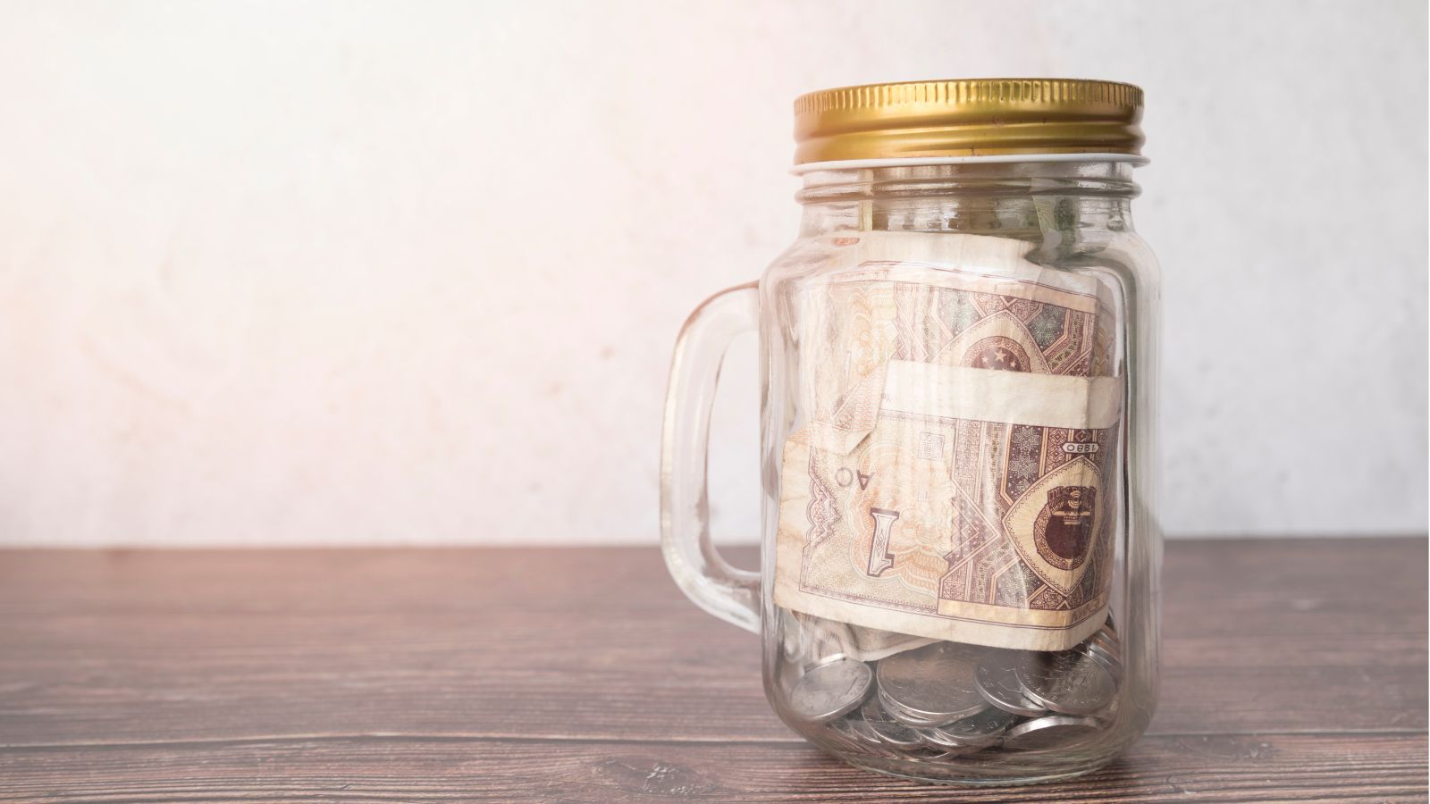 Family Drama: Man Confronts His Brother After Money Disappears From His Tip Jar A closed jar with handle and money inside