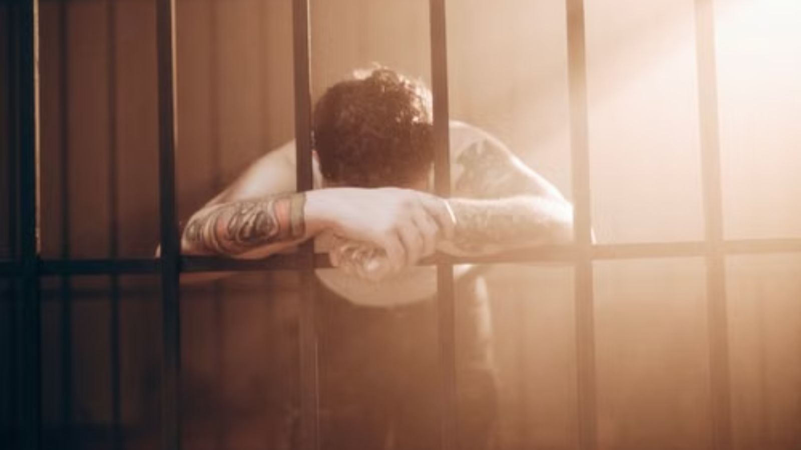 His Jailed Brother Wanted Him to Facilitate Outside Messages to Old Gang Ties—and His Family Resented Him for Saying No A tattooed man leans against prison bars