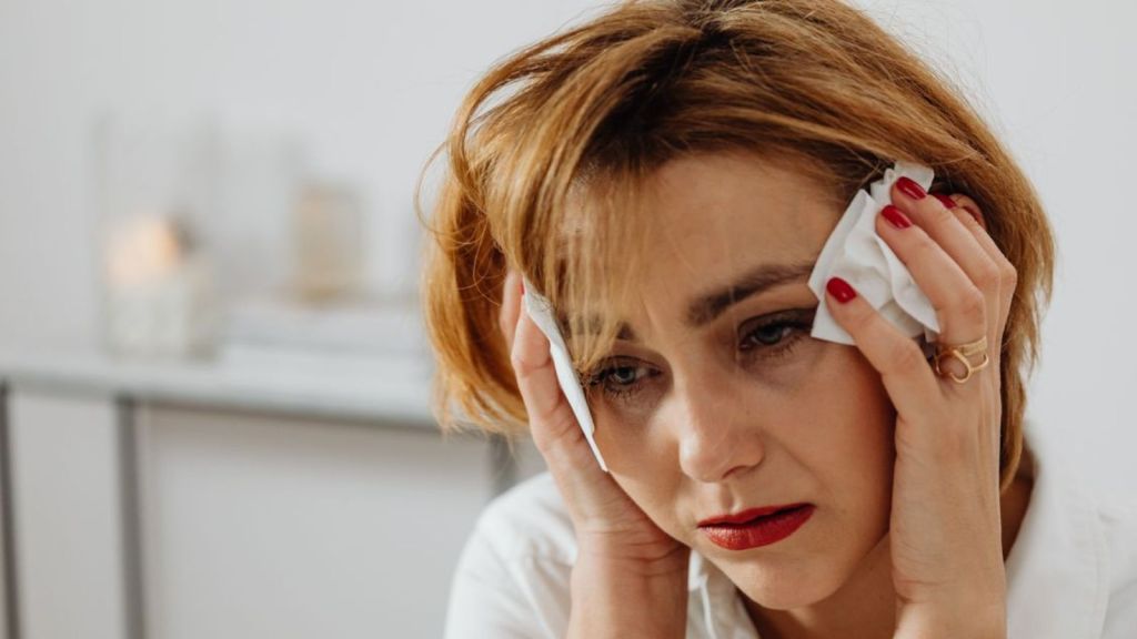 Woman feeling sad and crying at home