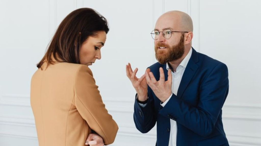 Boss in suit scolding a female employee